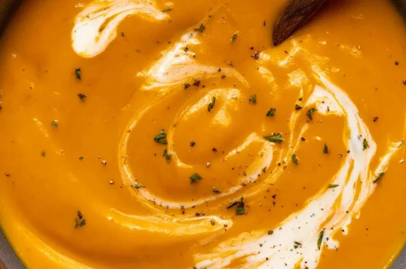 Bowl of Maple Roasted Sweet Potato Carrot Soup with a drizzle of maple syrup
