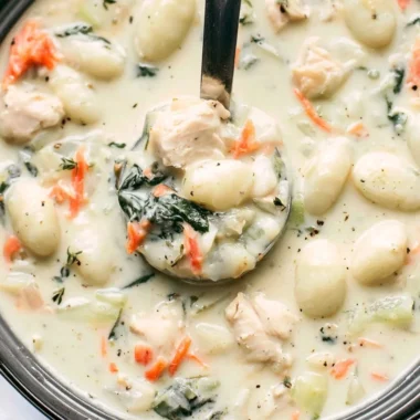 Bowl of Olive Garden Chicken Gnocchi Soup with fresh herbs on top